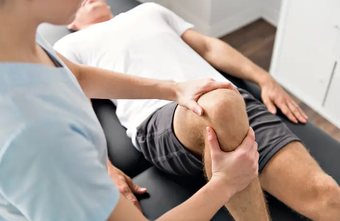 Fisioterapeuta tratando la rodilla de un empleado