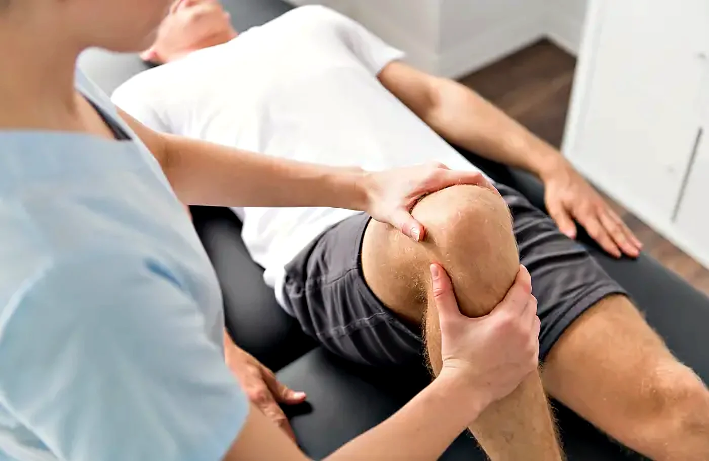 Fisioterapeuta tratando la rodilla de un empleado